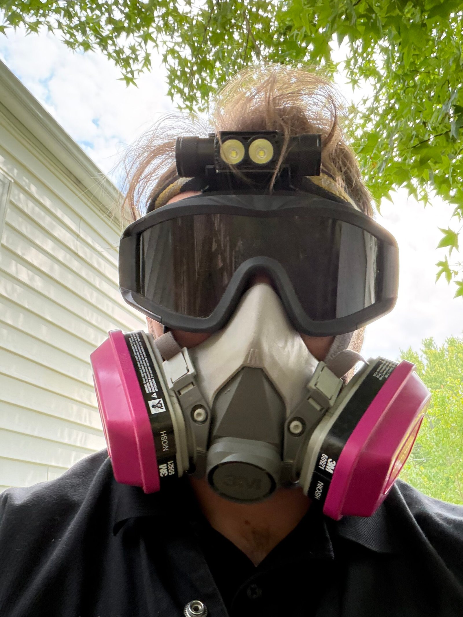 Inspector Harrison outfitted with respirator and suit for crawl space evaluation.