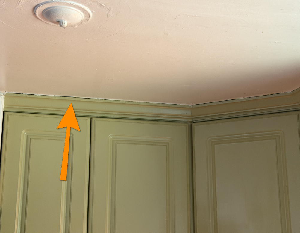 Kitchen cabinet pulling away from wall surface indicating floor sagging.