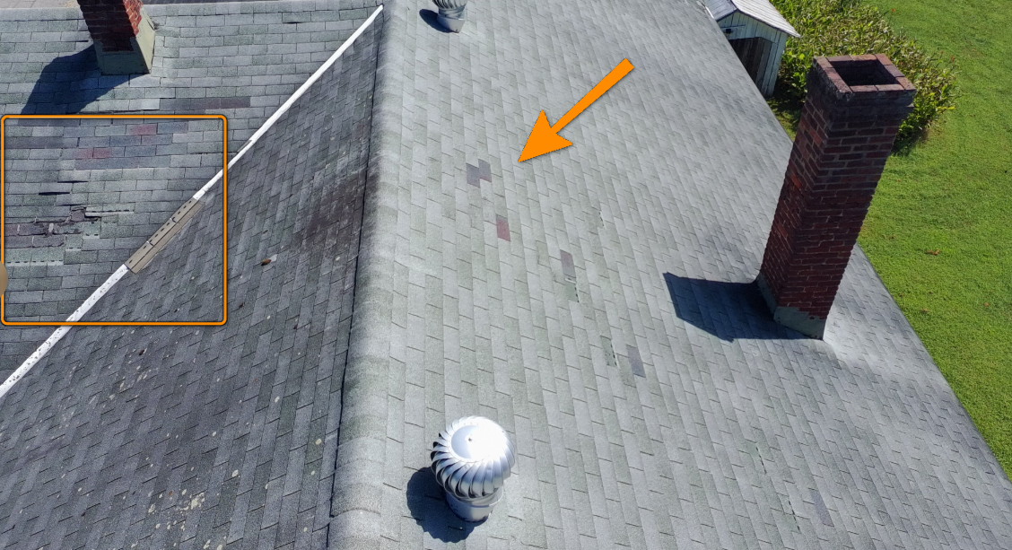 Damaged roof shingles surrounding open chimney flue missing cap.