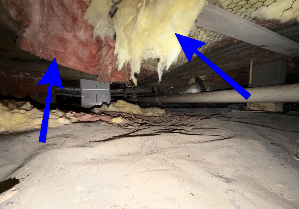 Fallen, sagging, and degraded fiberglass insulation under crawl space subfloor.