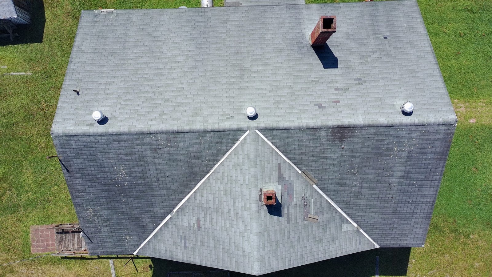 Downward angled drone image looking at roof shingles and gutters.