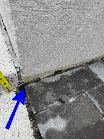 Structural crack and misaligned masonry indicating localized foundation settlement.