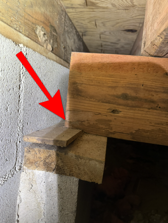 Subfloor girder beam with inadequate length shifting on compressible shims.