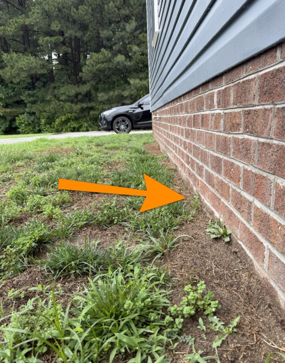 Soil sloping inward toward home foundation causing negative drainage.