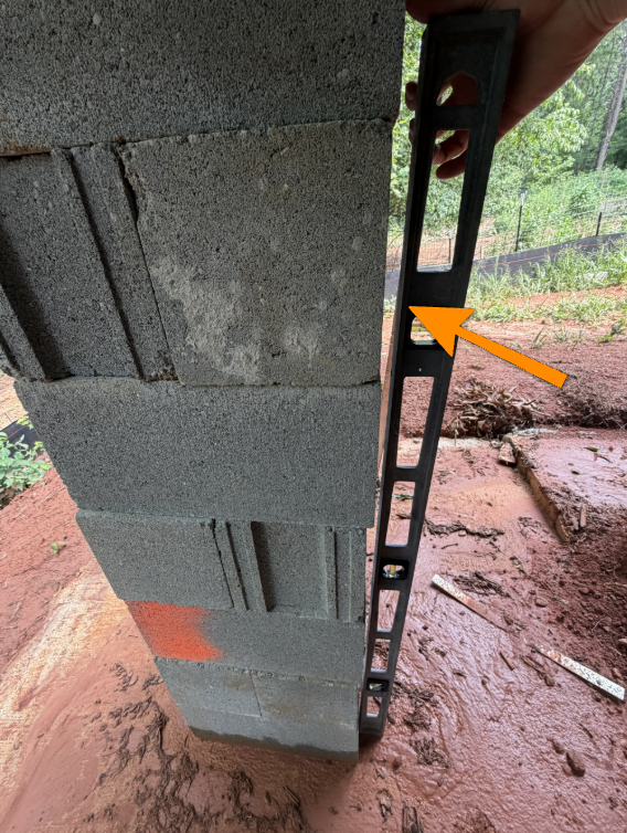 Foundation pier leaning out of plumb in crawl space.