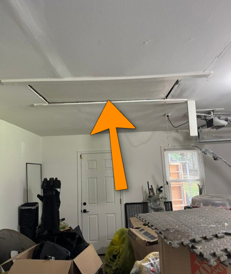 Unrated garage pull-down attic ladder breaching fire barrier.