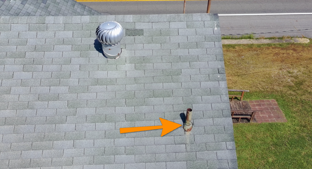 Asphalt roof shingle improperly overlapping an attic roof vent.